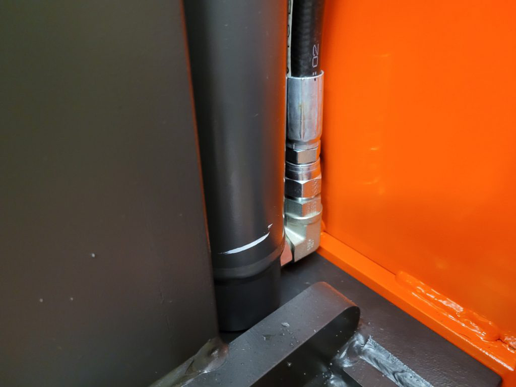 A close-up of the connection between the forklift’s mast hydraulic Cylinder and hose. Fluid is pump from the hose into the Cylinder to make the mast lift. Gravity brings the mast back down once the hose stops pumping.